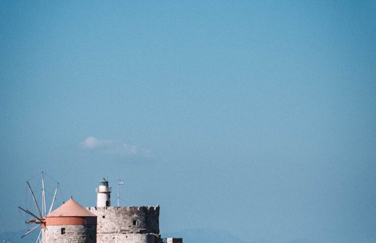 Explore the historic St. Nicholas Fortress and Lighthouse overlooking the Aegean Sea in Rhodes, Greece.