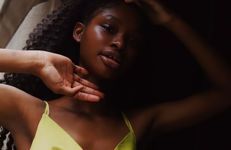 woman in yellow tank top lying on bed