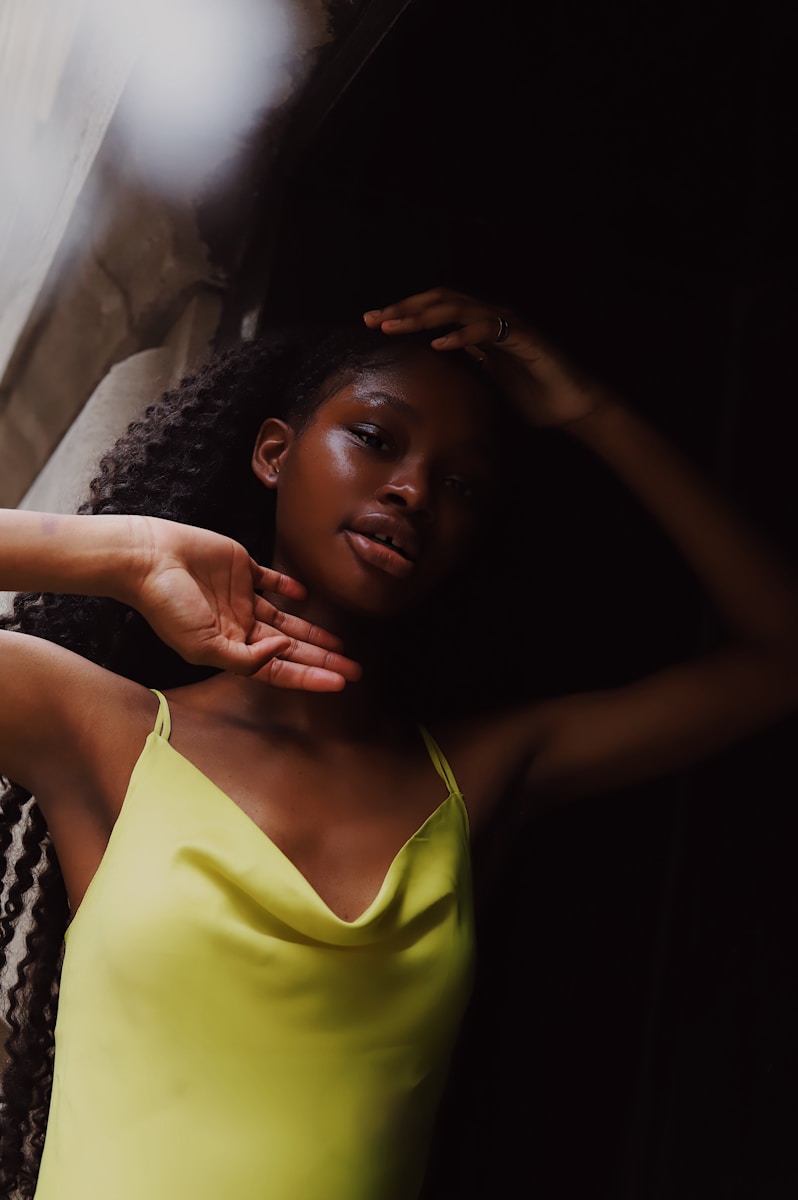 woman in yellow tank top lying on bed